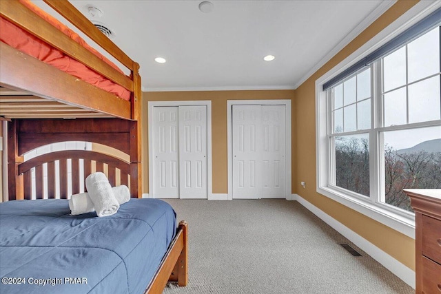 bedroom featuring visible vents, baseboards, multiple closets, carpet flooring, and recessed lighting