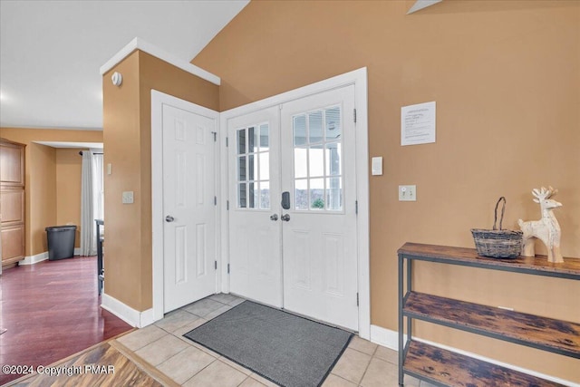 entrance foyer featuring light tile patterned flooring, french doors, and baseboards