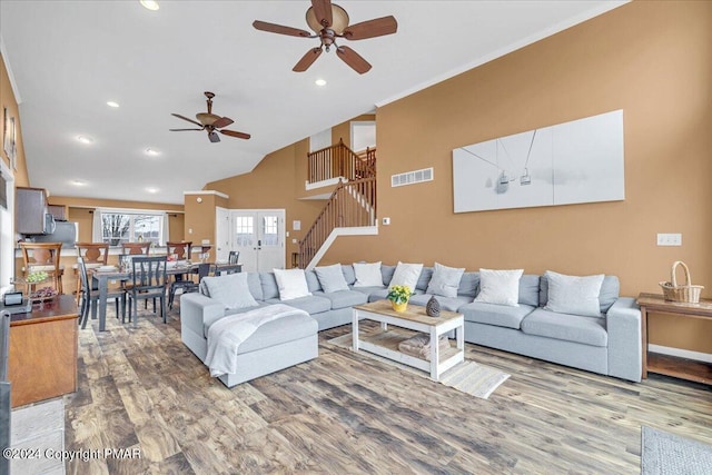 living room with visible vents, stairs, vaulted ceiling, recessed lighting, and wood finished floors