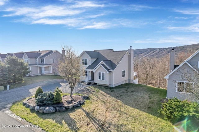 view of front of property featuring a front lawn, a residential view, and a chimney