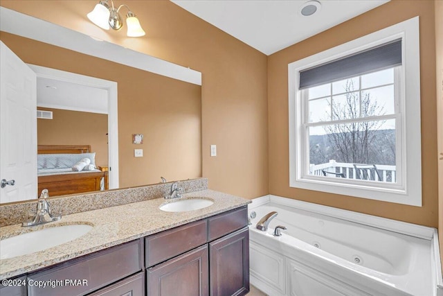 full bathroom with double vanity, a tub with jets, visible vents, and a sink