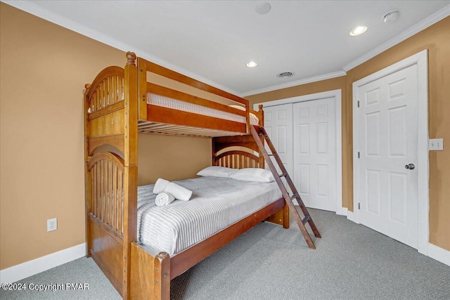 bedroom with visible vents, a closet, carpet floors, crown molding, and baseboards