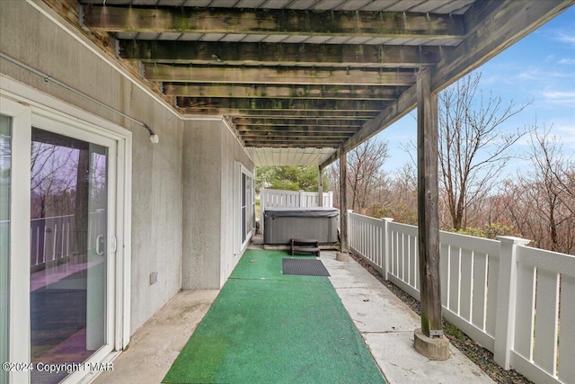 view of patio with fence and a hot tub