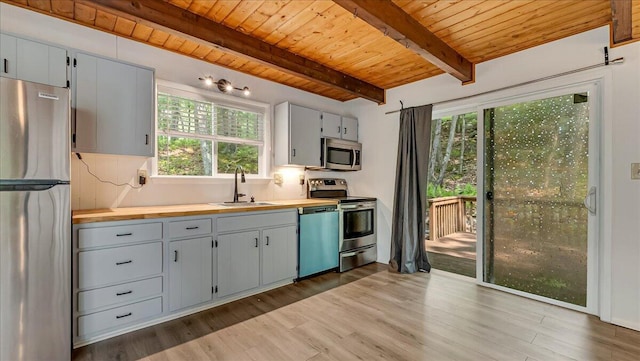 5015 Woodbridge Dr E, Bushkill, PA 18324 - kitchen with stainless steel appliances, a sink, wood ceiling with exposed beams, plenty of natural light, and light wood finished floors