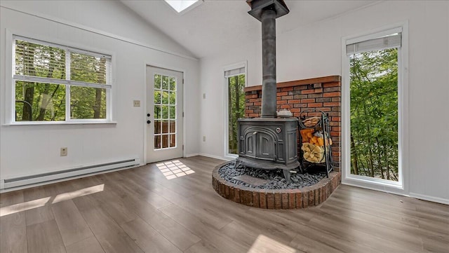 5015 Woodbridge Dr E, Bushkill, PA 18324 - living area with a wood stove, lofted ceiling, a baseboard radiator, wood finished floors, and baseboards