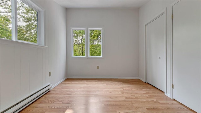 5015 Woodbridge Dr E, Bushkill, PA 18324 - unfurnished bedroom featuring a baseboard heating unit, light wood-style floors, and baseboards