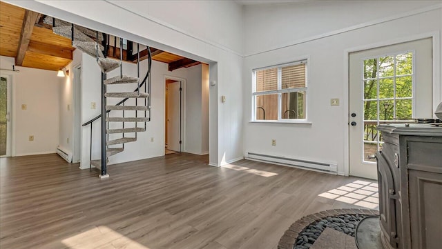 5015 Woodbridge Dr E, Bushkill, PA 18324 - unfurnished living room with a baseboard radiator, wood finished floors, stairs, beamed ceiling, and baseboards