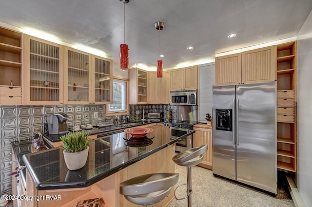 kitchen with a breakfast bar, a center island, stainless steel appliances, tasteful backsplash, and dark stone counters