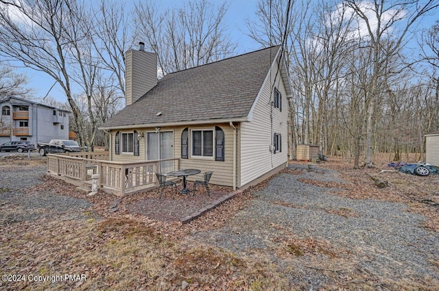 back of house featuring driveway and a chimney