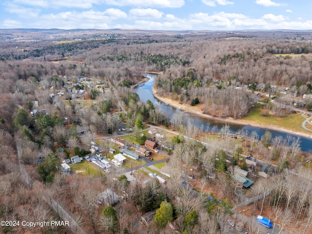 drone / aerial view featuring a water view and a wooded view