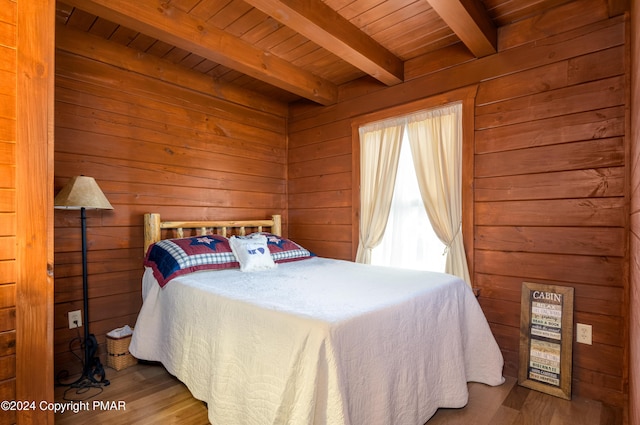 bedroom with wood finished floors, wood ceiling, and wooden walls