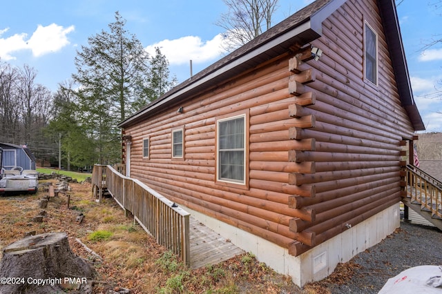 view of side of property with crawl space and log exterior