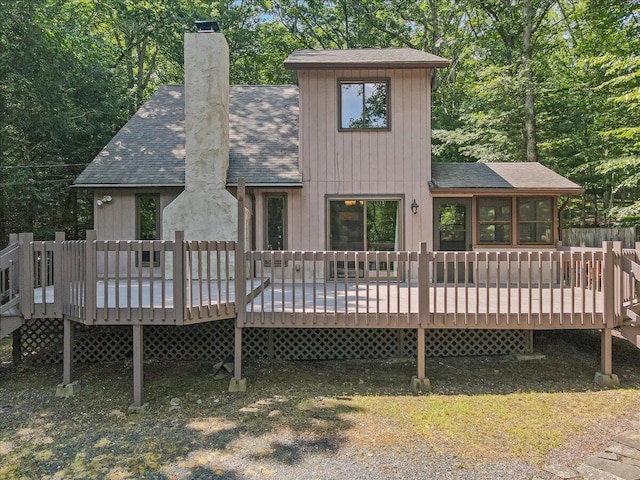 5913 NE Decker Rd NE, Bushkill, PA 18324 - back of property with a shingled roof, a chimney, and a wooden deck