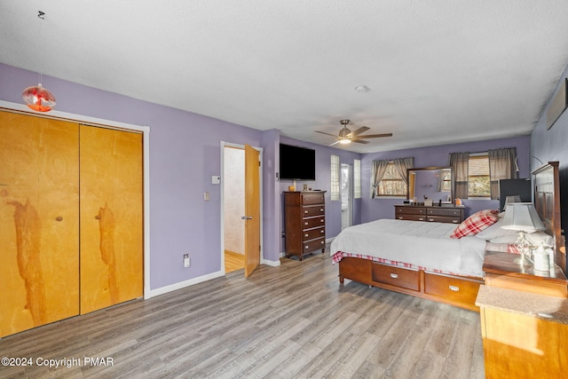 bedroom with a ceiling fan, baseboards, a textured ceiling, and light wood finished floors