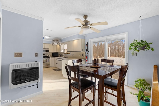 dining room with a textured ceiling, a ceiling fan, heating unit, light wood finished floors, and crown molding