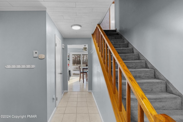 stairway featuring a ceiling fan, baseboards, and tile patterned floors