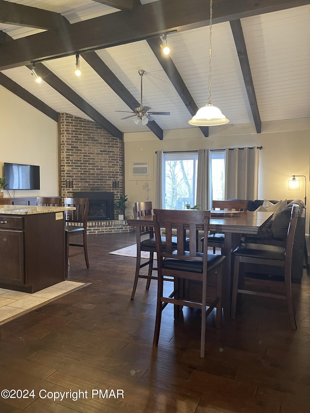 dining area with dark wood-style flooring, a fireplace, vaulted ceiling with beams, rail lighting, and a ceiling fan