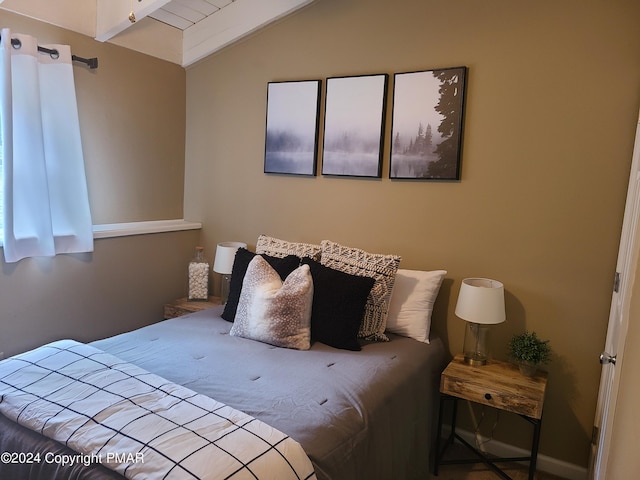 bedroom with vaulted ceiling with beams