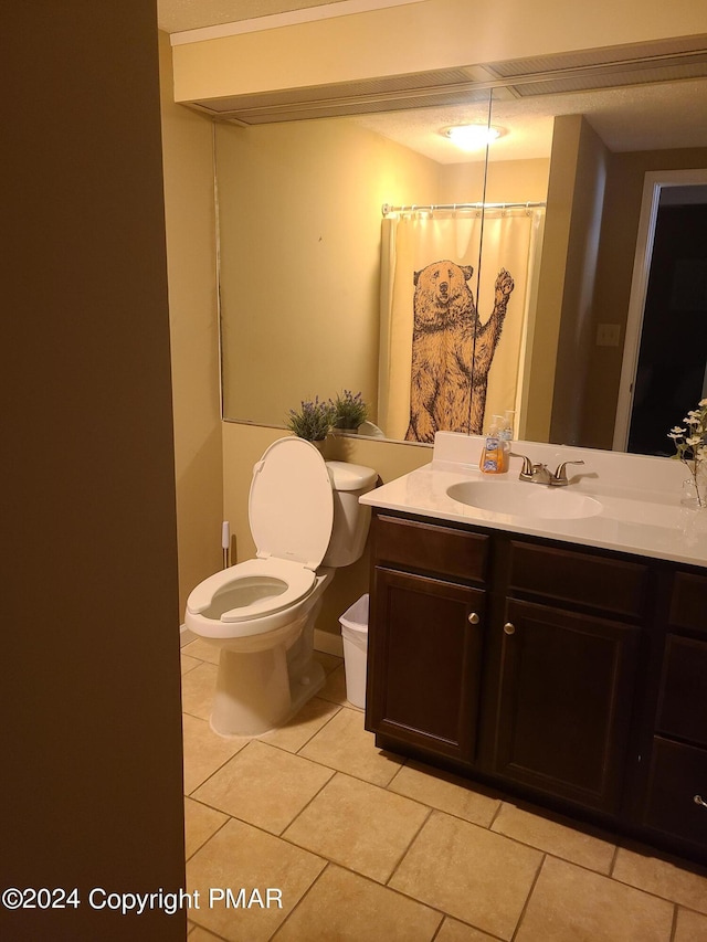 full bathroom with toilet, a shower with shower curtain, vanity, baseboards, and tile patterned floors