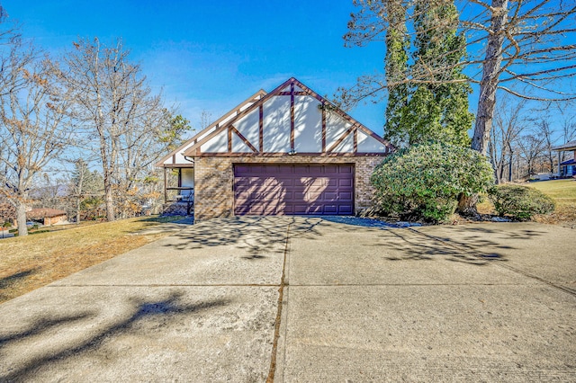 exterior space with brick siding, an attached garage, concrete driveway, and a front yard