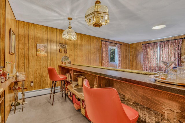 bar with wooden walls, baseboard heating, a bar, and carpet