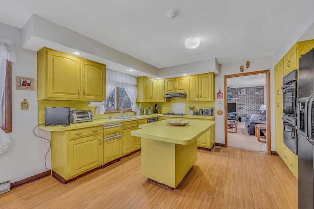 kitchen featuring oven, a sink, under cabinet range hood, a kitchen island, and light countertops