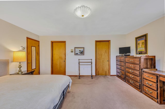 bedroom featuring light colored carpet and baseboards