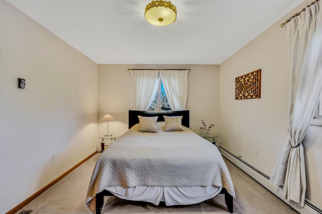 bedroom with light carpet, a baseboard heating unit, and baseboards