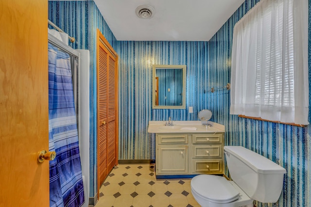 bathroom featuring visible vents, wallpapered walls, baseboards, toilet, and vanity