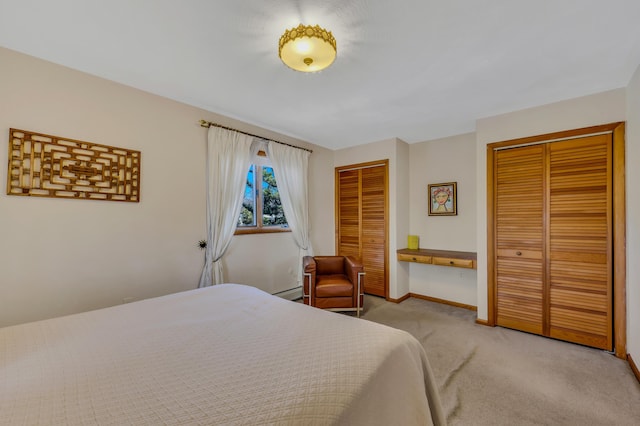 bedroom featuring baseboards, multiple closets, light carpet, and a baseboard heating unit