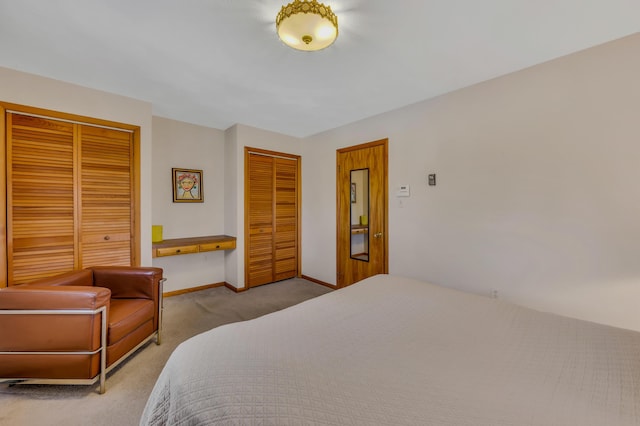 carpeted bedroom featuring baseboards and multiple closets