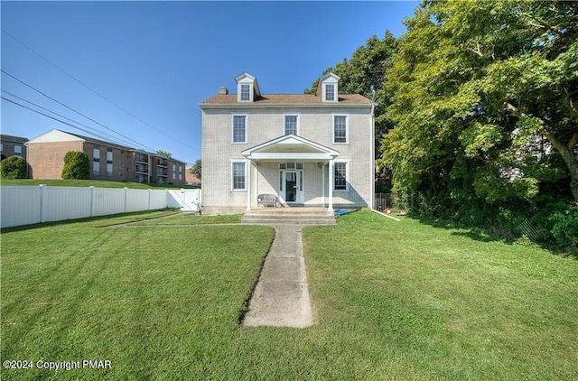 view of front facade with a front lawn and fence