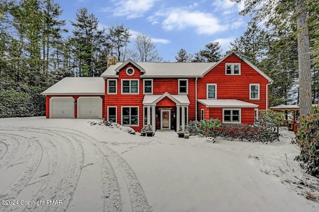 view of front of property featuring an attached garage, driveway, and a chimney