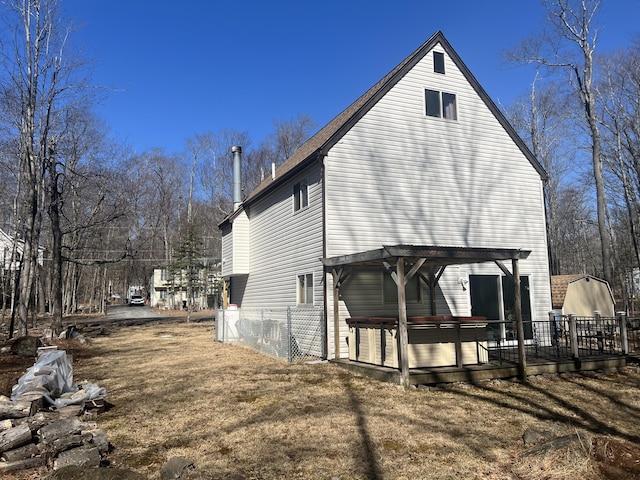 view of home's exterior with a covered hot tub, a wooden deck, and a pergola