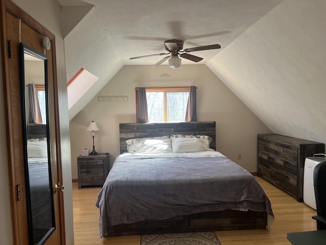 bedroom with vaulted ceiling, a ceiling fan, and light wood finished floors