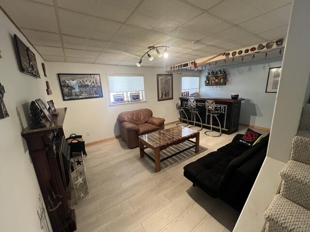 living room featuring baseboards, wood finished floors, and a dry bar