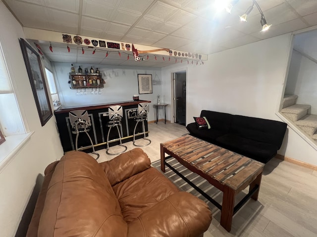 living room with baseboards, wood finished floors, stairs, and a dry bar