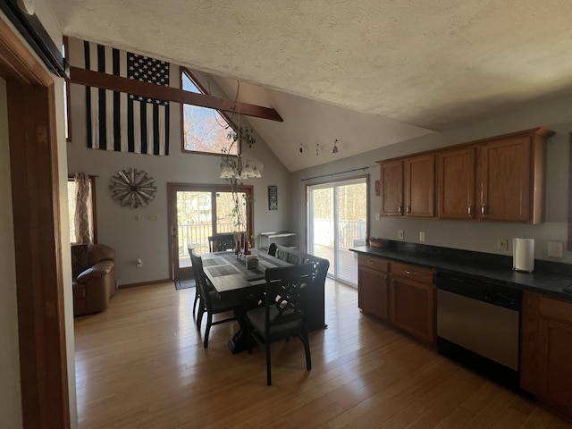 dining area featuring high vaulted ceiling, a textured ceiling, light wood-style floors, baseboards, and a chandelier