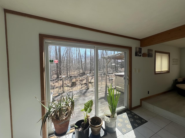 doorway to outside with tile patterned floors, baseboards, and beam ceiling