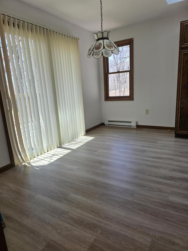 166 Applewood Dr, Swiftwater, PA 18370 - unfurnished dining area with a baseboard heating unit, a chandelier, wood finished floors, and baseboards