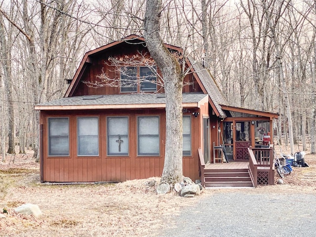 chalet / cabin with a gambrel roof and a shingled roof