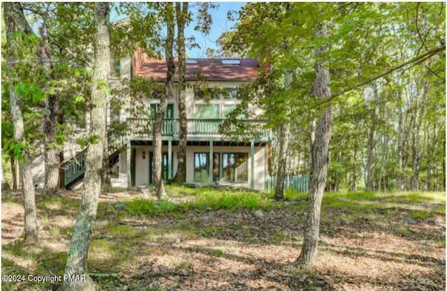 rear view of property with stairway and a wooden deck