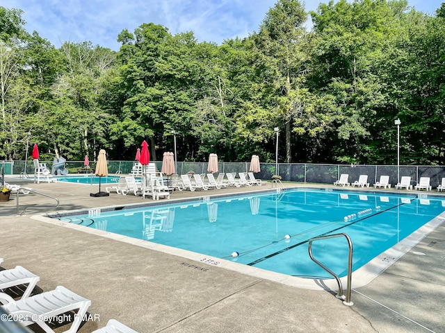 pool with fence and a patio