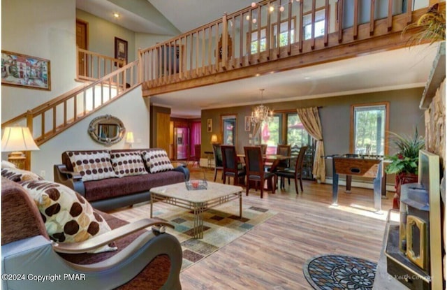 living room featuring a chandelier, stairs, a high ceiling, and wood finished floors