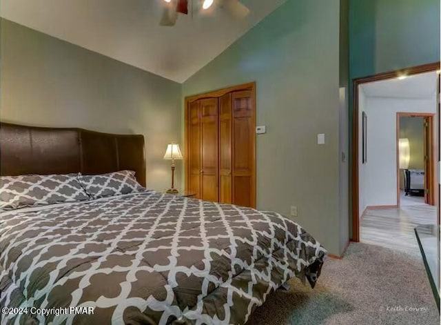 carpeted bedroom with ceiling fan, high vaulted ceiling, and a closet