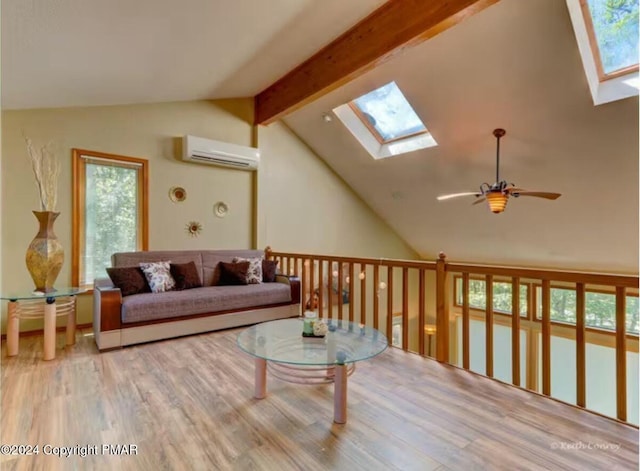 living area with vaulted ceiling with skylight, a wall mounted air conditioner, and wood finished floors