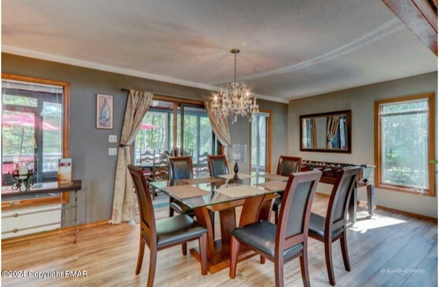 dining space featuring light wood-style flooring and a chandelier