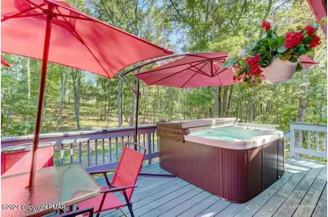 wooden terrace featuring outdoor dining area and a hot tub