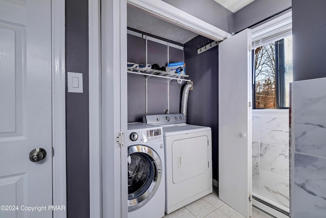 clothes washing area featuring independent washer and dryer, light tile patterned floors, and a baseboard heating unit