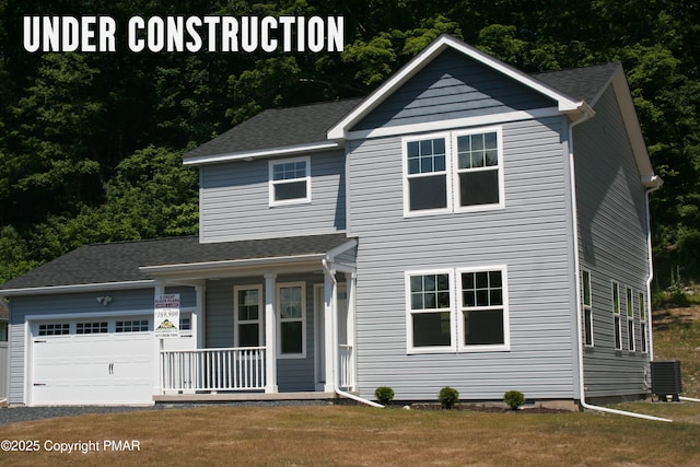 view of front of property with an attached garage, a porch, central AC unit, and a front lawn
